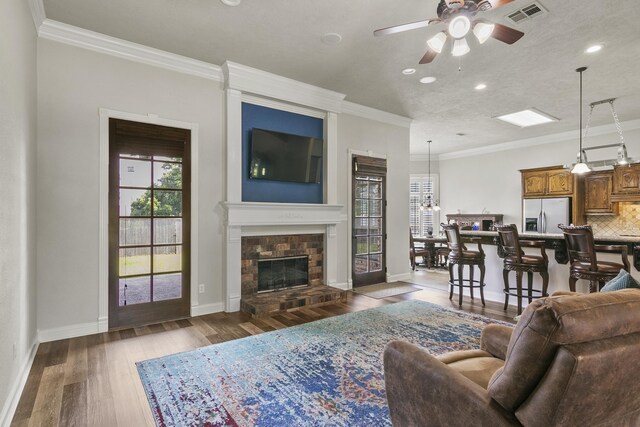 living room featuring dark hardwood / wood-style flooring, crown molding, and ceiling fan