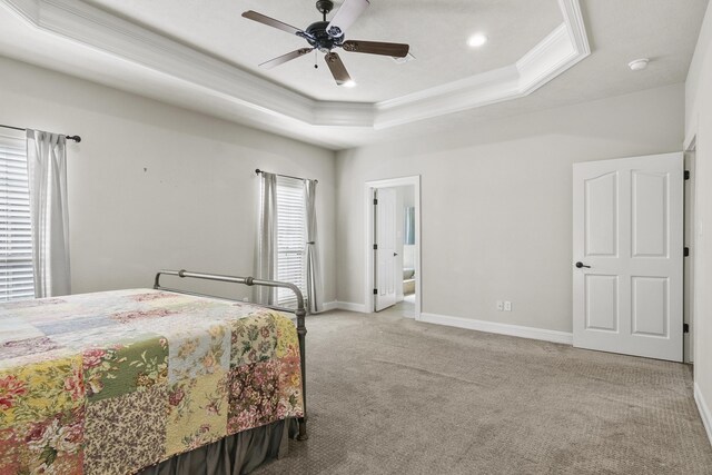 bedroom featuring crown molding, light colored carpet, a raised ceiling, and ceiling fan