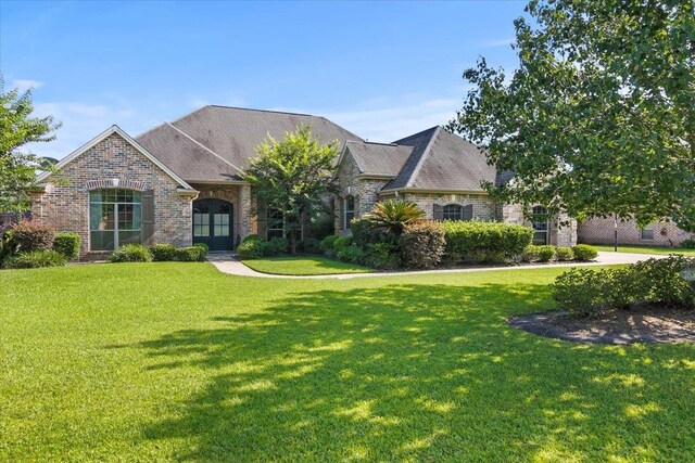 french country inspired facade with a lawn