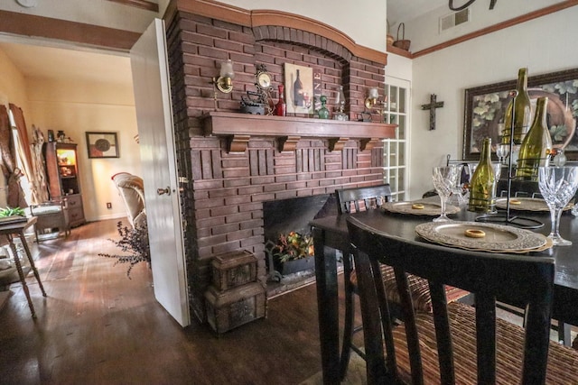 dining room with wood-type flooring and a fireplace