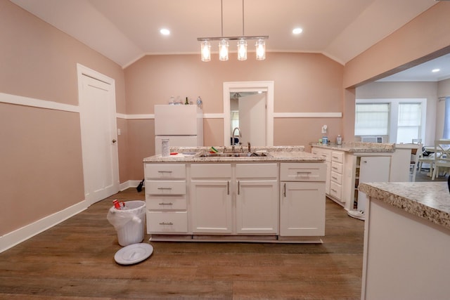 kitchen featuring sink, a center island, white cabinetry, hanging light fixtures, and lofted ceiling