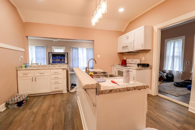 kitchen with sink, white appliances, decorative light fixtures, a center island with sink, and white cabinets