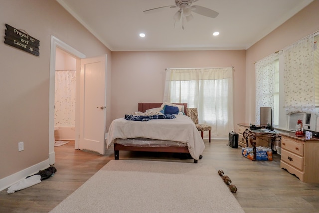 bedroom featuring ceiling fan, light hardwood / wood-style floors, ornamental molding, and connected bathroom