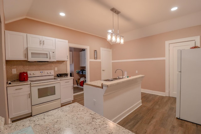 kitchen with backsplash, white appliances, vaulted ceiling, decorative light fixtures, and white cabinets