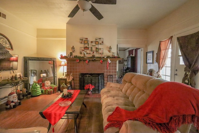 living room featuring ceiling fan and a tile fireplace