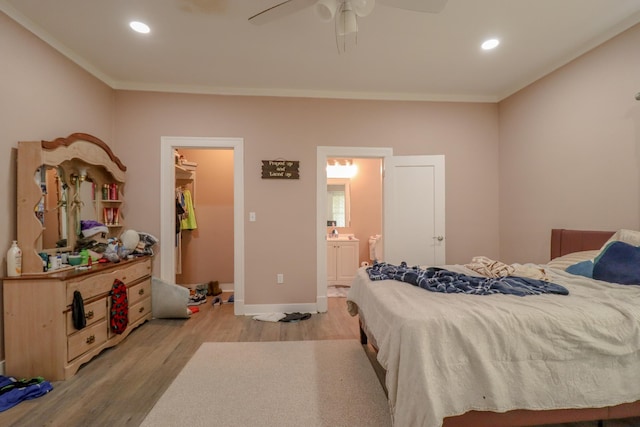 bedroom with connected bathroom, ceiling fan, light hardwood / wood-style flooring, and crown molding