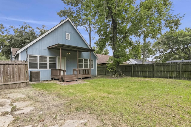 rear view of property with a yard and a wooden deck