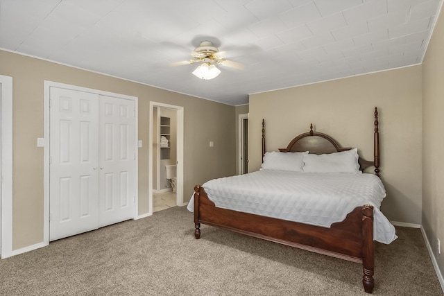 carpeted bedroom featuring ceiling fan, ensuite bath, and a closet