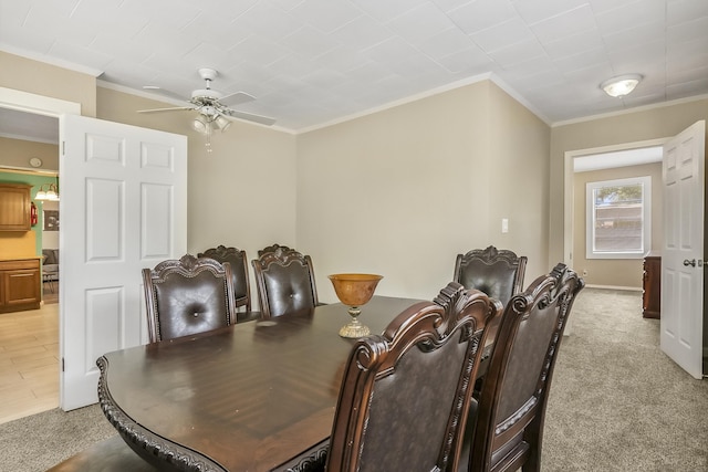 carpeted dining space with ceiling fan and crown molding