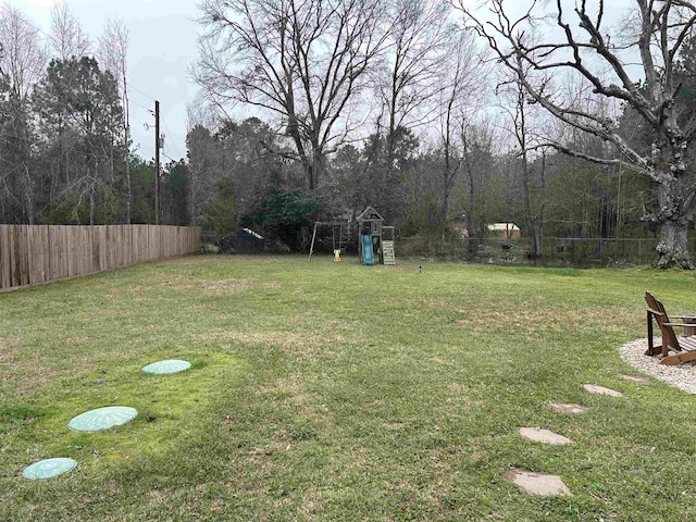 view of yard featuring fence and a playground