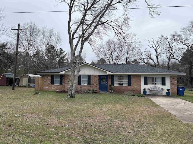 view of front of home featuring a storage unit, a front lawn, an outdoor structure, and brick siding