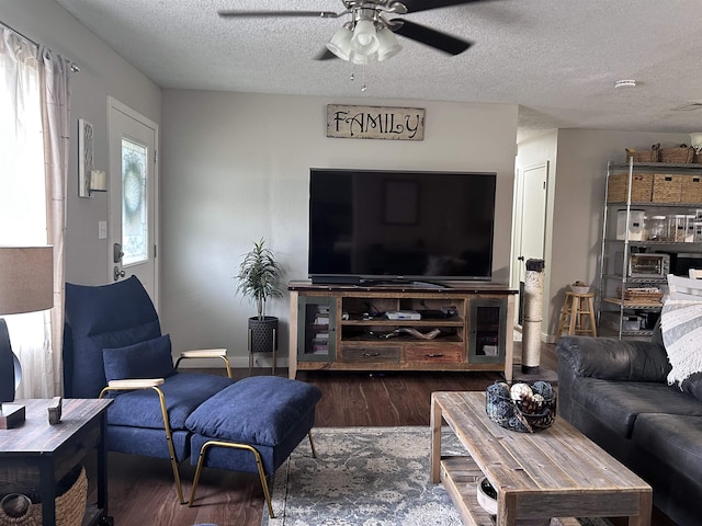 living area with a textured ceiling, ceiling fan, and wood finished floors