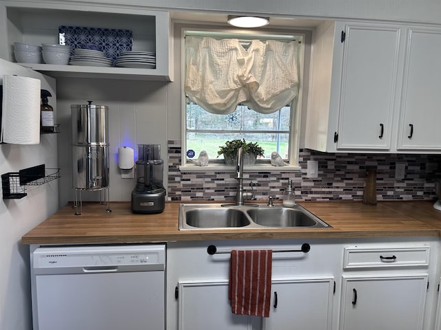 kitchen with tasteful backsplash, butcher block counters, white dishwasher, and a sink