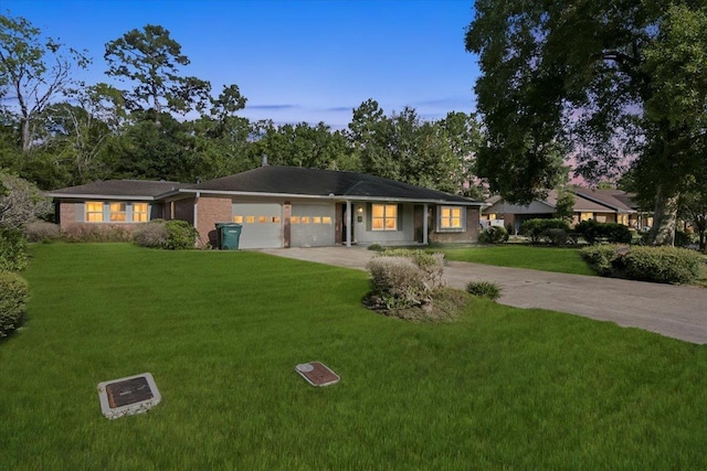 ranch-style house featuring a garage and a lawn