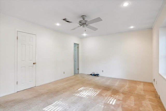 spare room with ceiling fan, ornamental molding, and light carpet