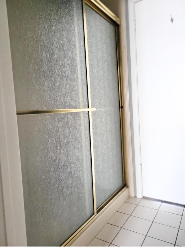 bathroom featuring tile patterned floors and a shower with door