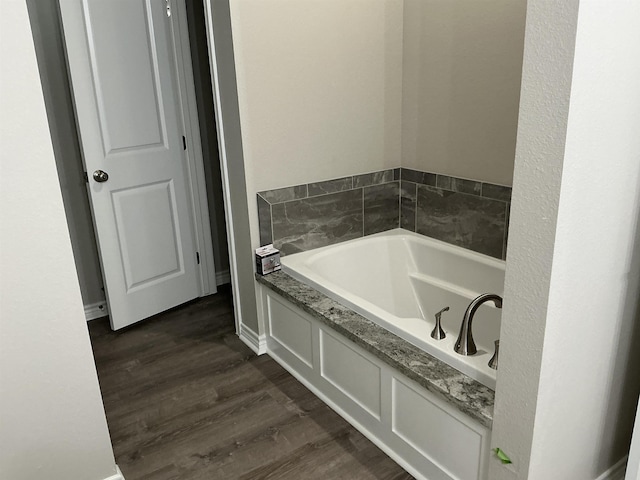 bathroom featuring hardwood / wood-style flooring and a bath