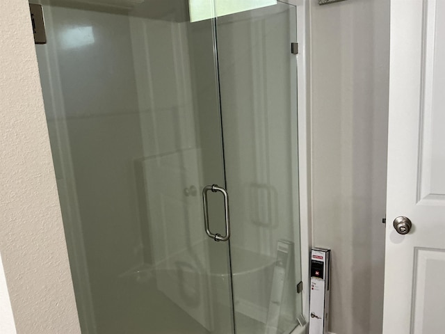 bathroom with a shower with door