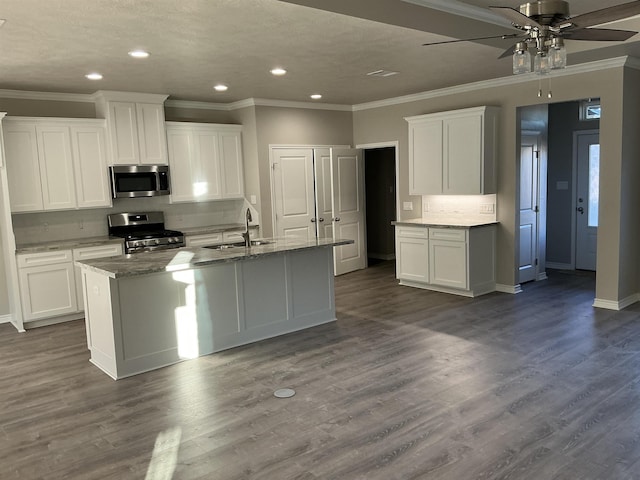 kitchen with white cabinetry, hardwood / wood-style floors, a kitchen island with sink, and stainless steel appliances