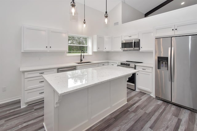 kitchen with a sink, a center island, white cabinetry, and stainless steel appliances