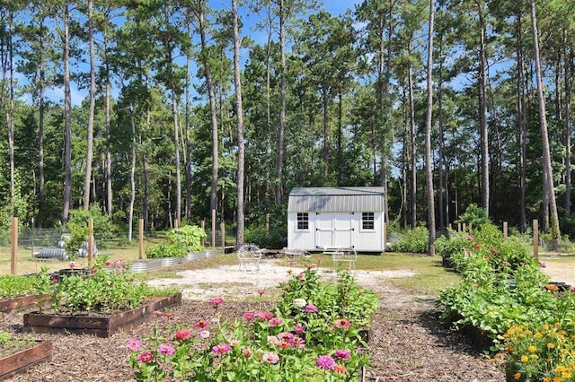 view of yard with an outdoor structure, a vegetable garden, and a shed