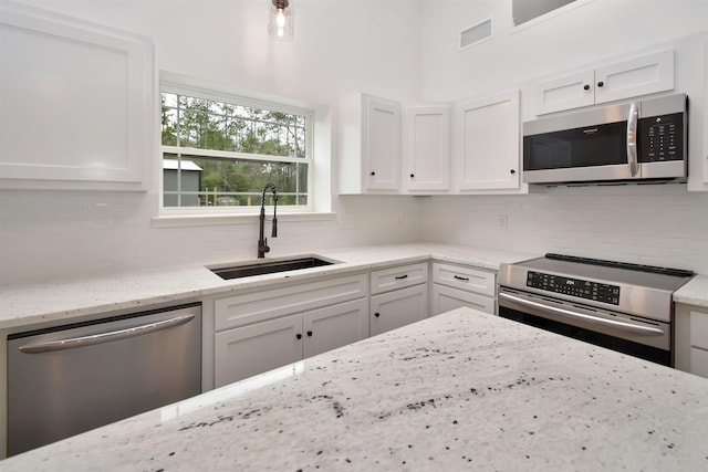 kitchen featuring visible vents, a sink, white cabinets, appliances with stainless steel finishes, and tasteful backsplash