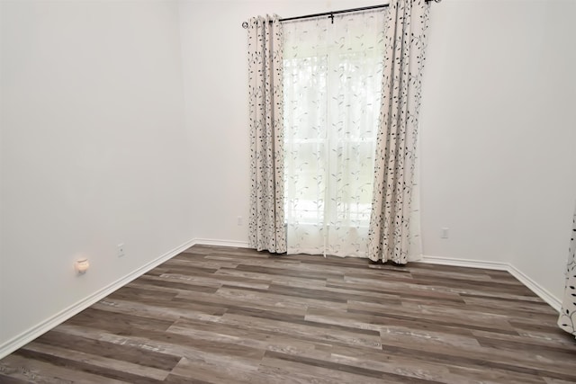 empty room with baseboards and wood finished floors