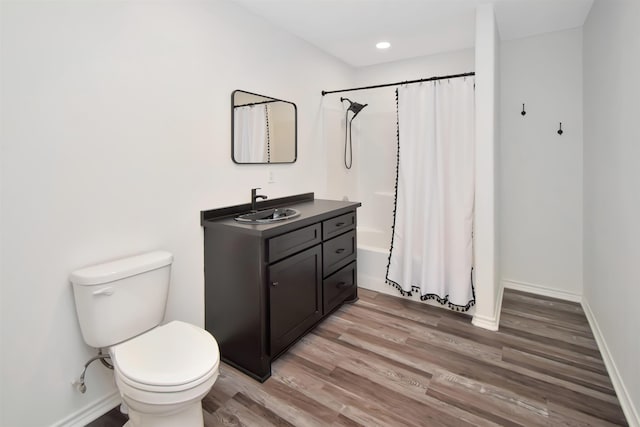 full bathroom featuring baseboards, toilet, shower / tub combo with curtain, wood finished floors, and vanity