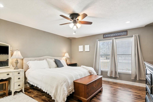 bedroom with a textured ceiling, dark wood-type flooring, and ceiling fan