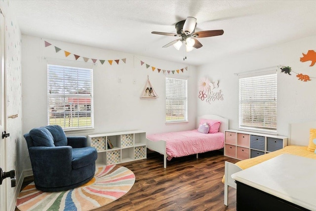 bedroom with dark hardwood / wood-style flooring and ceiling fan