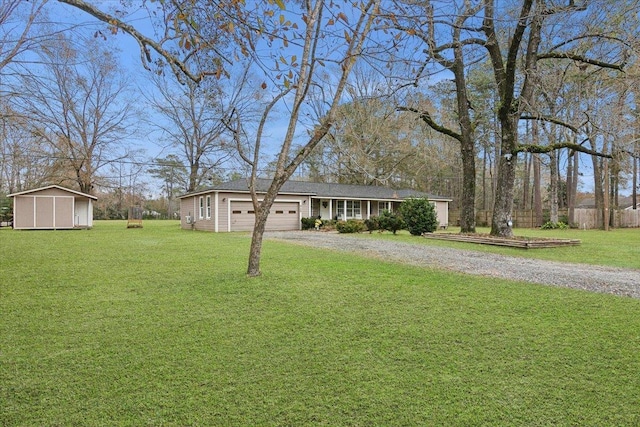 ranch-style home featuring a storage shed, a garage, and a front yard