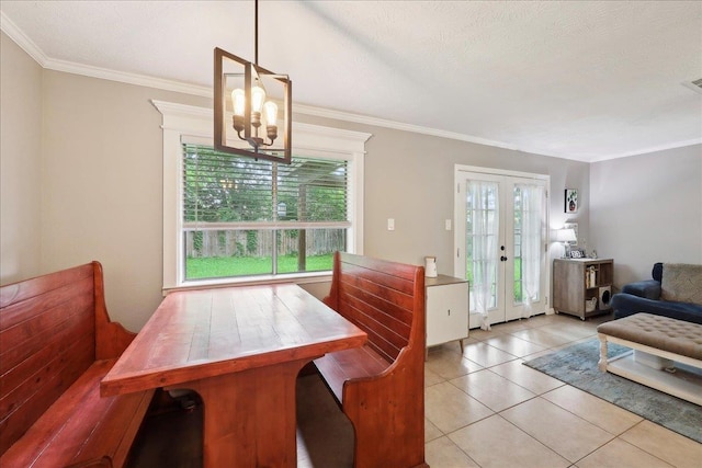 dining space with tile patterned floors, an inviting chandelier, french doors, and crown molding