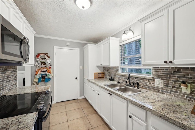 kitchen featuring tasteful backsplash, stainless steel microwave, a sink, white cabinetry, and black electric range oven