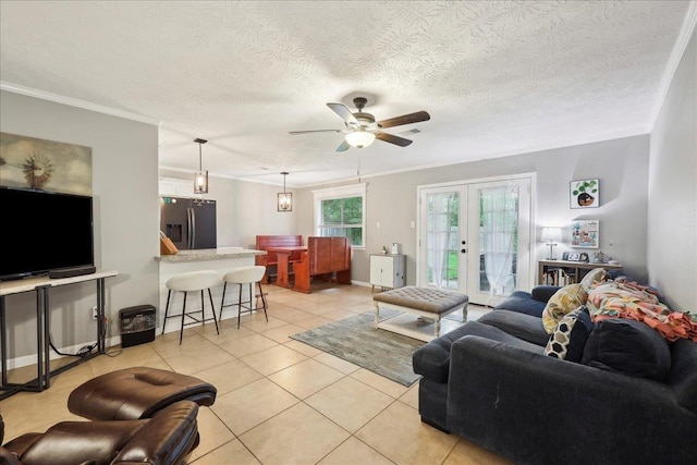living area with crown molding, ceiling fan, and light tile patterned floors