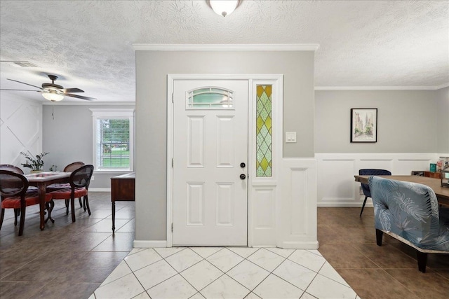 foyer featuring light tile patterned floors, a decorative wall, and a textured ceiling