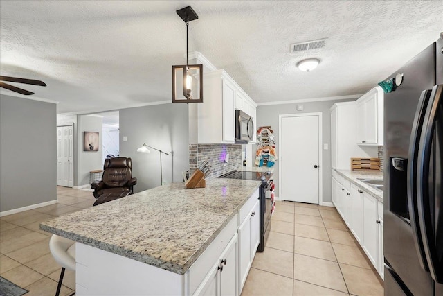 kitchen with light tile patterned floors, visible vents, appliances with stainless steel finishes, and decorative backsplash