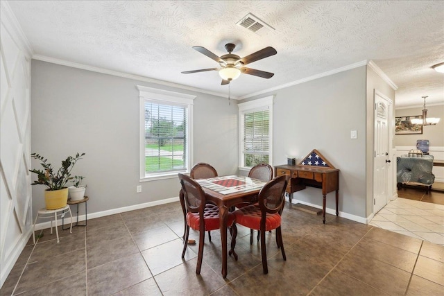 dining space featuring ornamental molding, tile patterned flooring, visible vents, and ceiling fan with notable chandelier