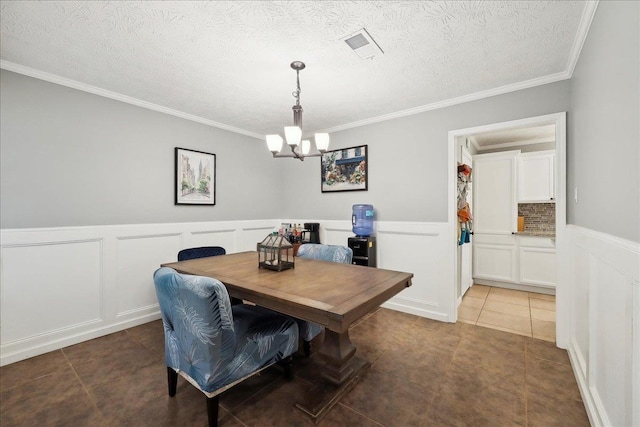 dining area with wainscoting, light tile patterned floors, an inviting chandelier, and a decorative wall