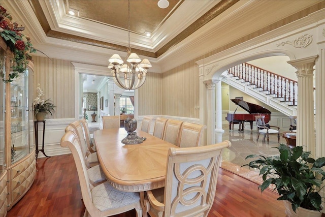 7510 Shadow Creek Dr, Beaumont, TX 77707 - dining room featuring a decorative wall, a chandelier, ornate columns, wood finished floors, and arched walkways
