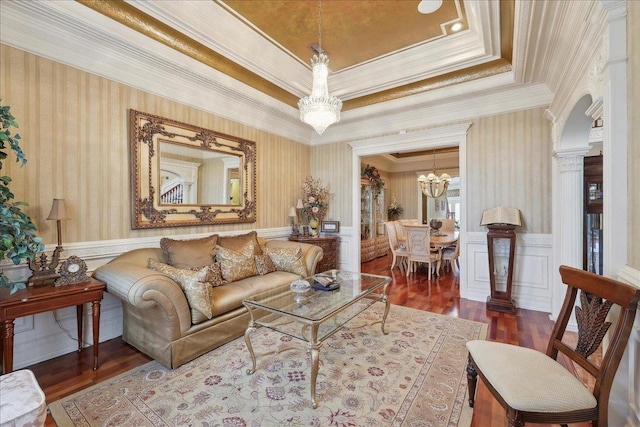 7510 Shadow Creek Dr, Beaumont, TX 77707 - living room featuring a chandelier, wood finished floors, crown molding, a raised ceiling, and arched walkways