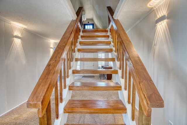 stairway featuring carpet and a textured ceiling