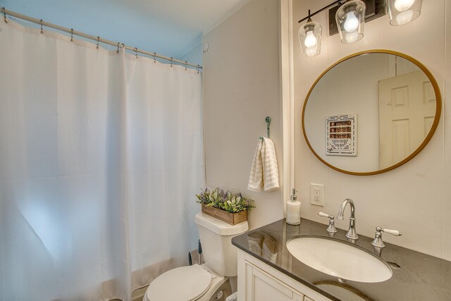 bathroom with walk in shower, vanity, and toilet