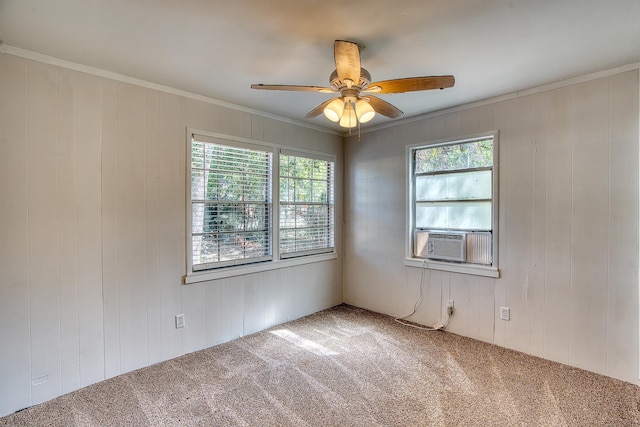 carpeted spare room featuring wood walls, ceiling fan, cooling unit, and ornamental molding