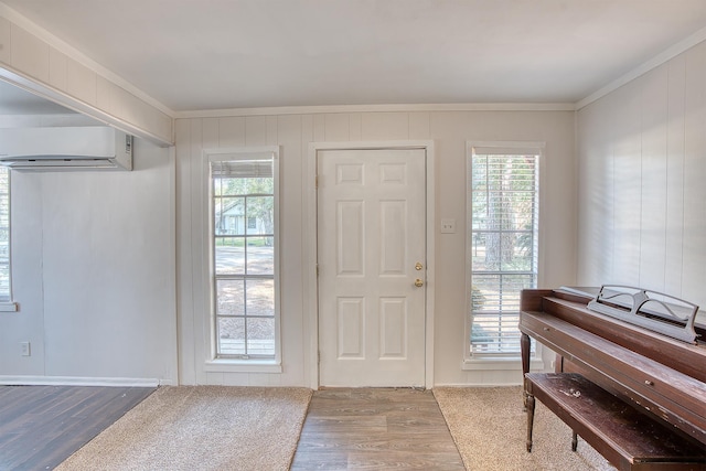 entryway featuring hardwood / wood-style flooring, crown molding, and a wall mounted AC