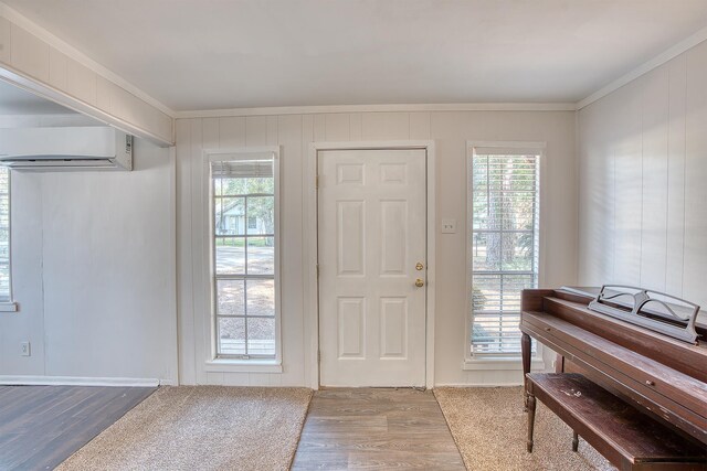 entryway featuring hardwood / wood-style flooring, crown molding, and a wall mounted AC