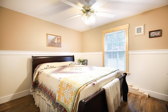 bedroom with ceiling fan, dark wood-type flooring, and multiple windows