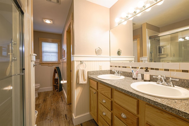 bathroom with hardwood / wood-style flooring, vanity, toilet, and an enclosed shower