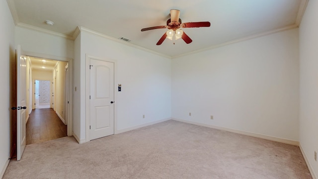 interior space featuring crown molding, visible vents, a ceiling fan, light carpet, and baseboards