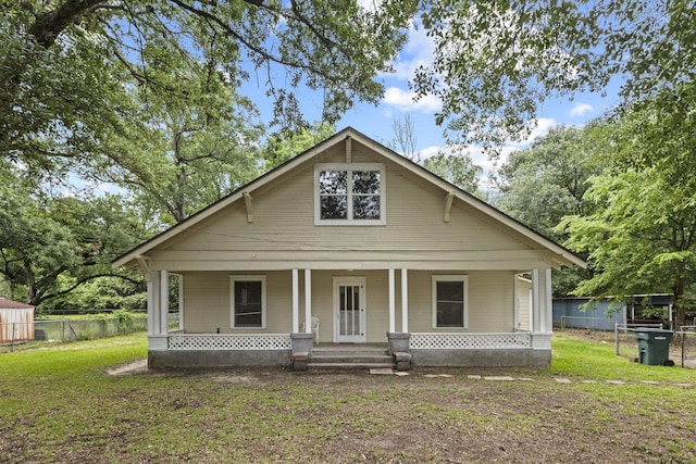 bungalow featuring a porch, fence, and a front yard