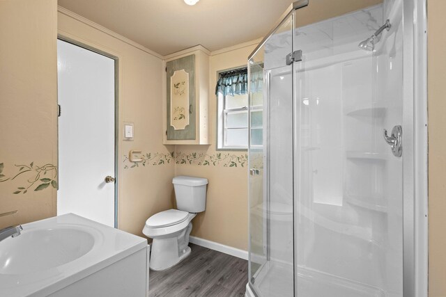 full bath with ornamental molding, a shower stall, toilet, and wood finished floors